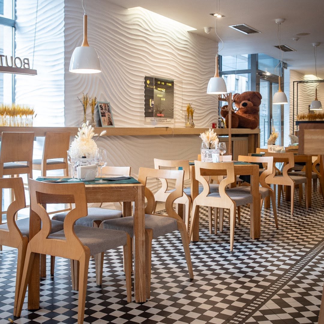 Interiorul Boutique du Pain, cu podea în carouri și scaune din lemn deschis, unul dintre restaurantele cu meniu de prânz din București