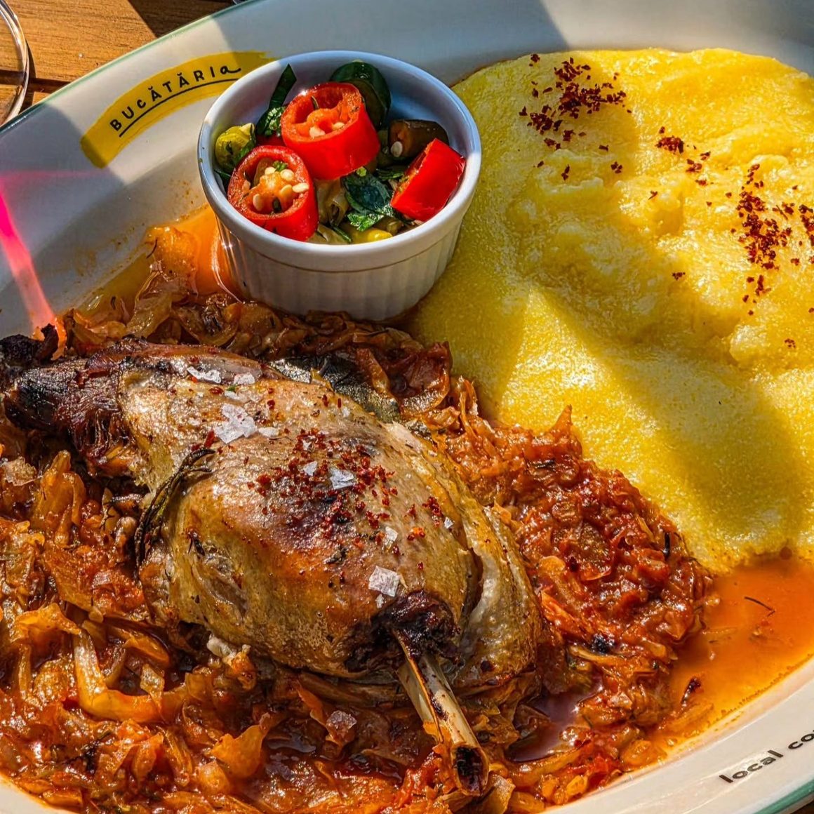 Ciolan de porc cu varză călită și mămăligă, fel de la Bucătăria.localfood, unul dintre restaurantele cu meniu de prânz din București