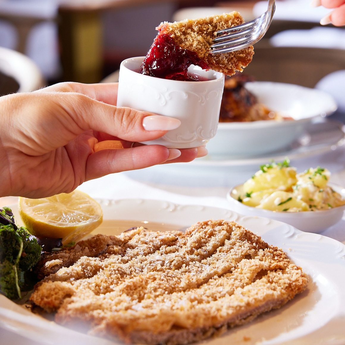 Șnițel vienez de vită servit cu dulceață și o salată mică din cartofi. casa Fratelli