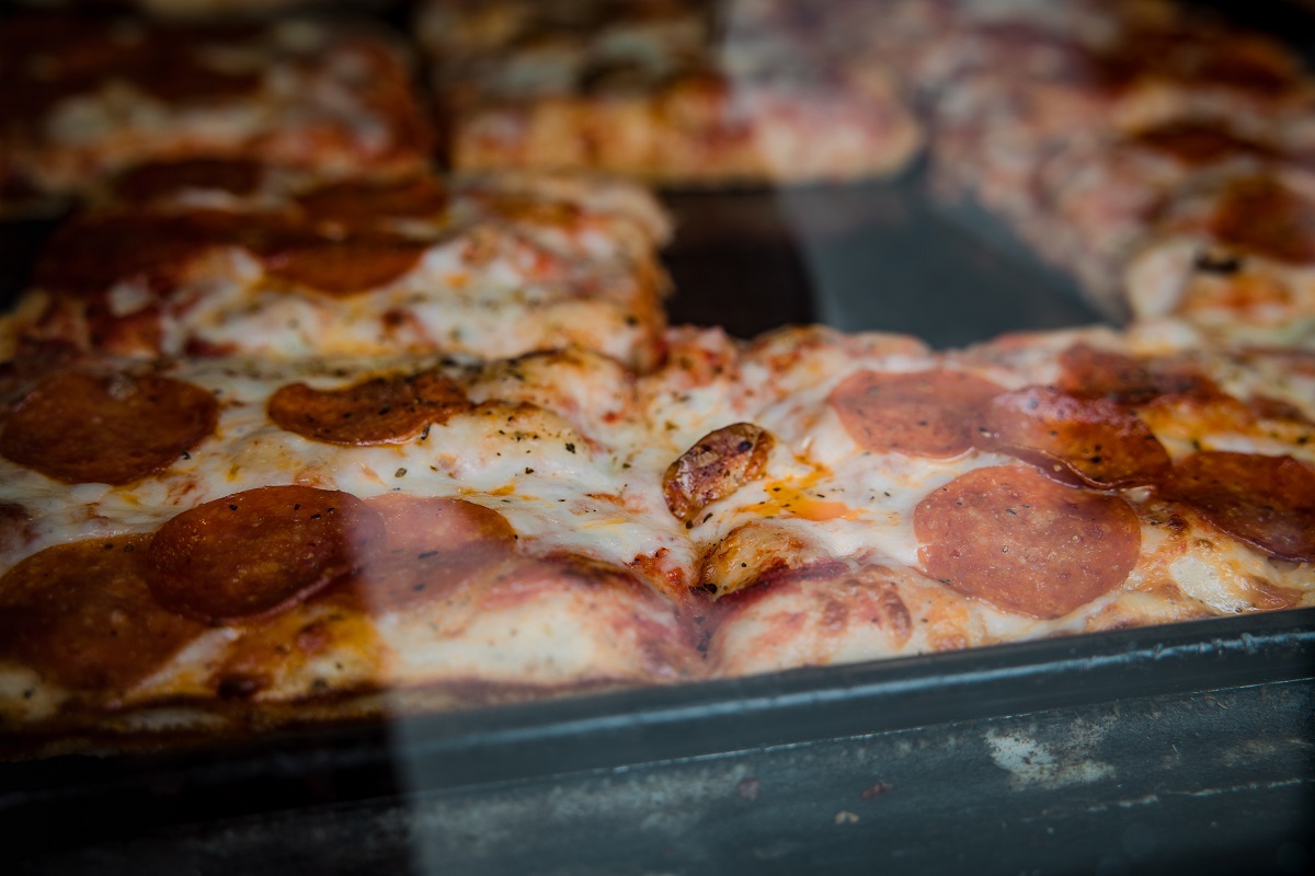 pizza pepperoni fotografiata prin geamul de sticla de la cuptor in timp ce se coace