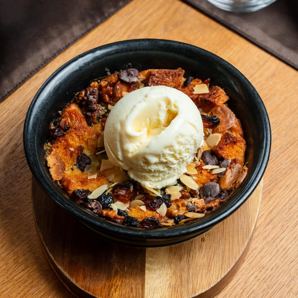 Budincă de cozonac cu ciocoalată albă și ciocolată neagră, migdale, miez de nucă și coajă de citrice