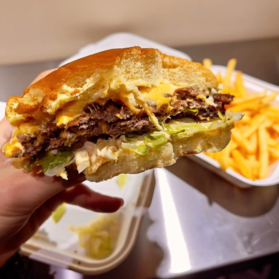 closeup cu un burger smashed, cu salata si cheddar