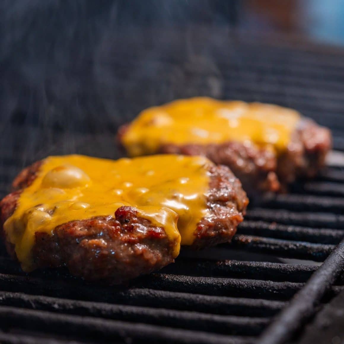 Burger de vită pe grătar cu cheddar topit, surprins în timpul preparării la Osho Restaurant, unul dintre locurile apreciate pentru cei mai buni burgeri din București.
