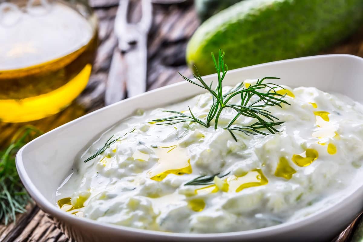 close up cu un bol de tzatziki, cele mai populare sosuri din lume, sos grecesc cu iaurt, ulei de masline, castravete ras si marar proaspat
