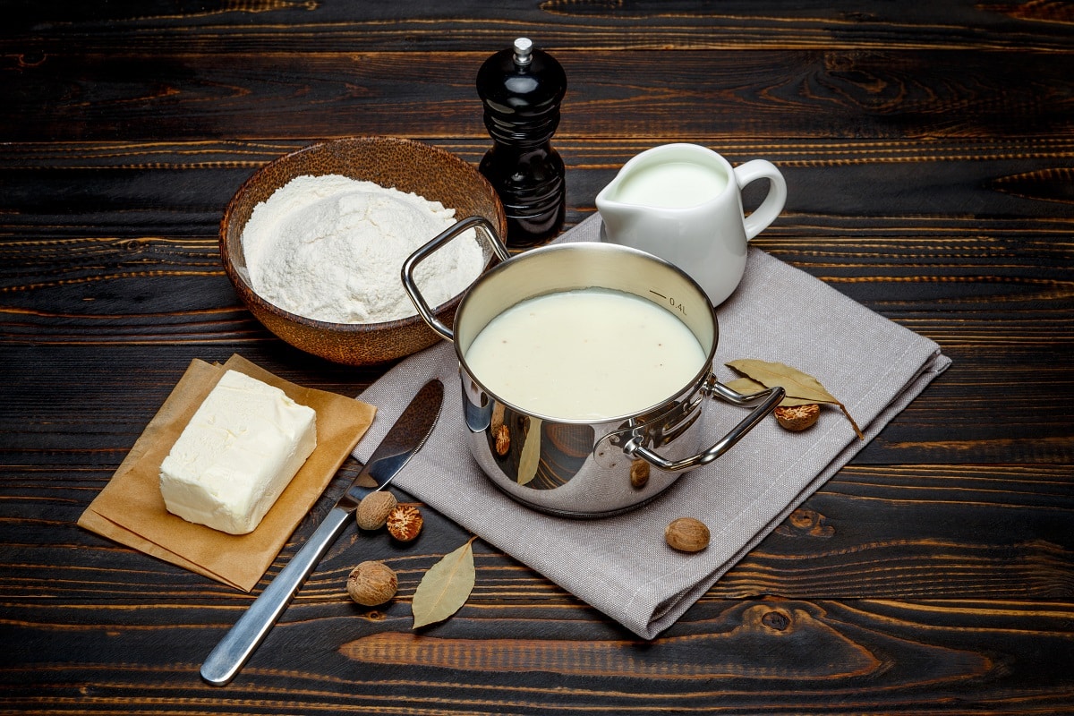 Prepararea sosului bechamel intr-un cratita de inox si ingredientele necesare, asezate langa:  faina, unt, lapte. Unul dintre cele mai populare sosuri din lume