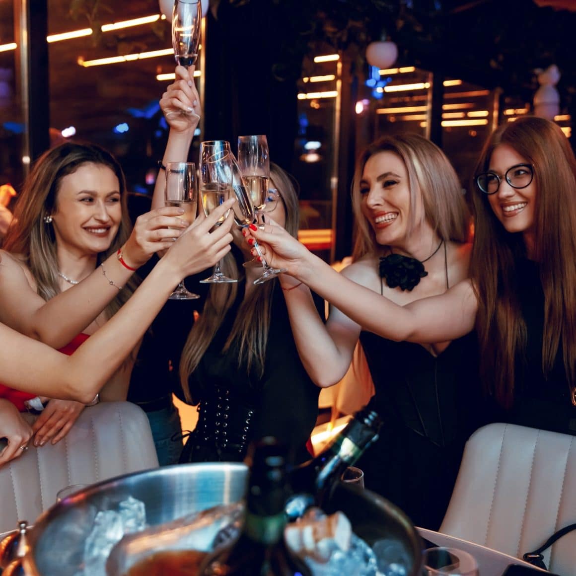 Grup de prietene care ciocnesc pahare de șampanie la Naive București, rooftop restaurant și club, perfectă pentru o petrecere de restaurante 8 martie