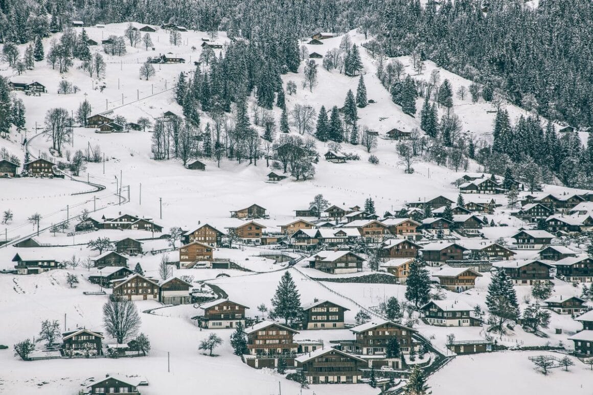peisaje pitoresti din jurul Grindelwald cu munti si un sat rasfirat in zapada.