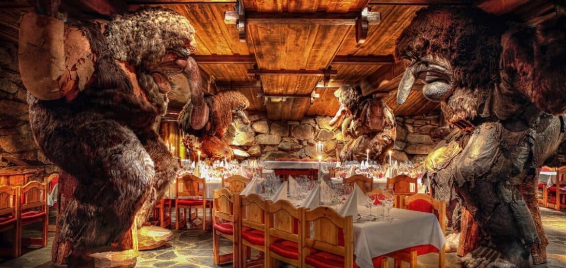 interiorul restaurantului Trollsalen din Hunderfossen  surprinde prin butaforia care reprezinta nistre troli sculptati din lemn