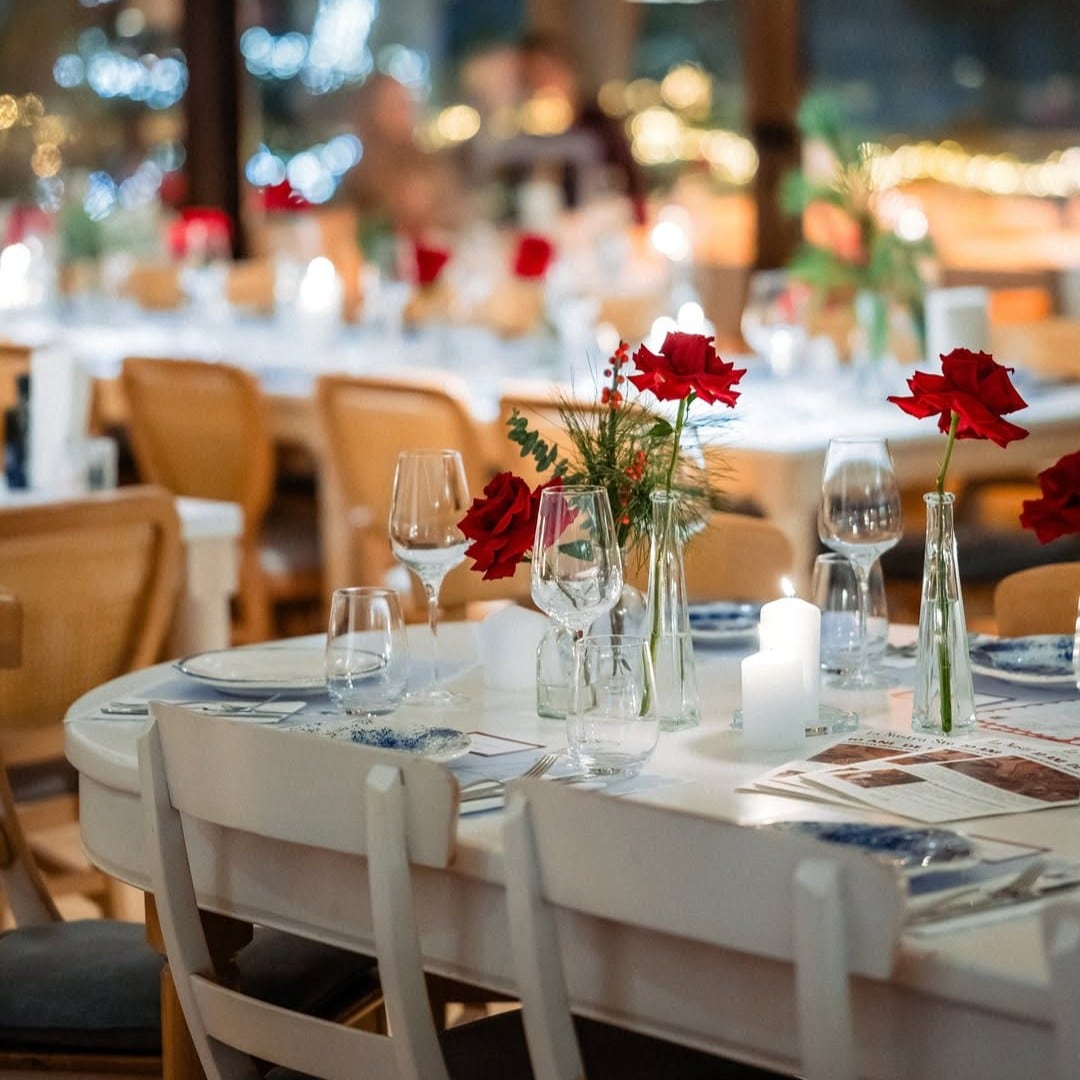 Mese albe cu trandafiri roșii și lumânări la Fior di Latte București, restaurant italian pentru o cină romantică