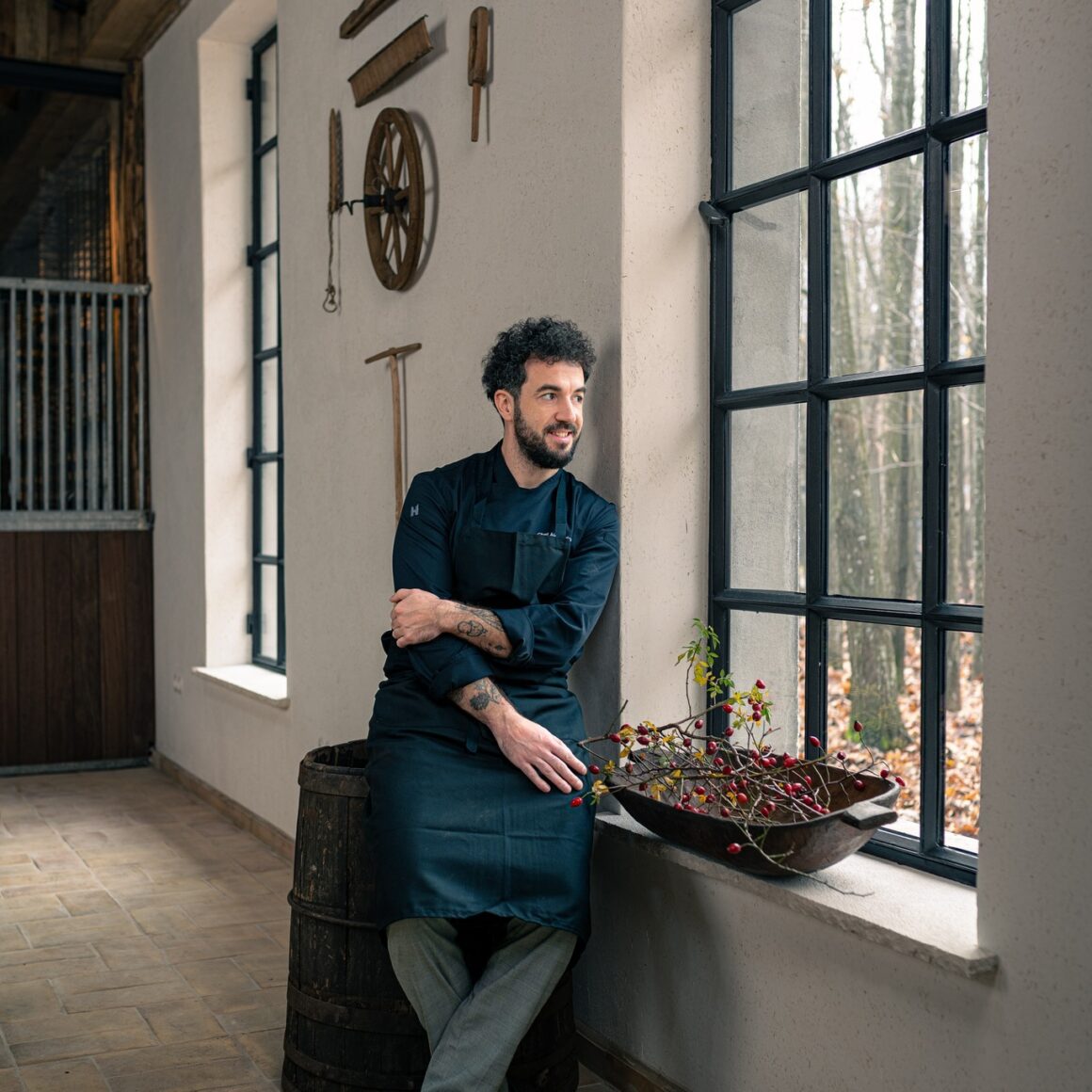 Chef Alexandru Dumitru fotografiat in dreptul unei ferestre mari de la restaurant La Hambar, SIngureni Manor, unul din restaurante destinatie din țară