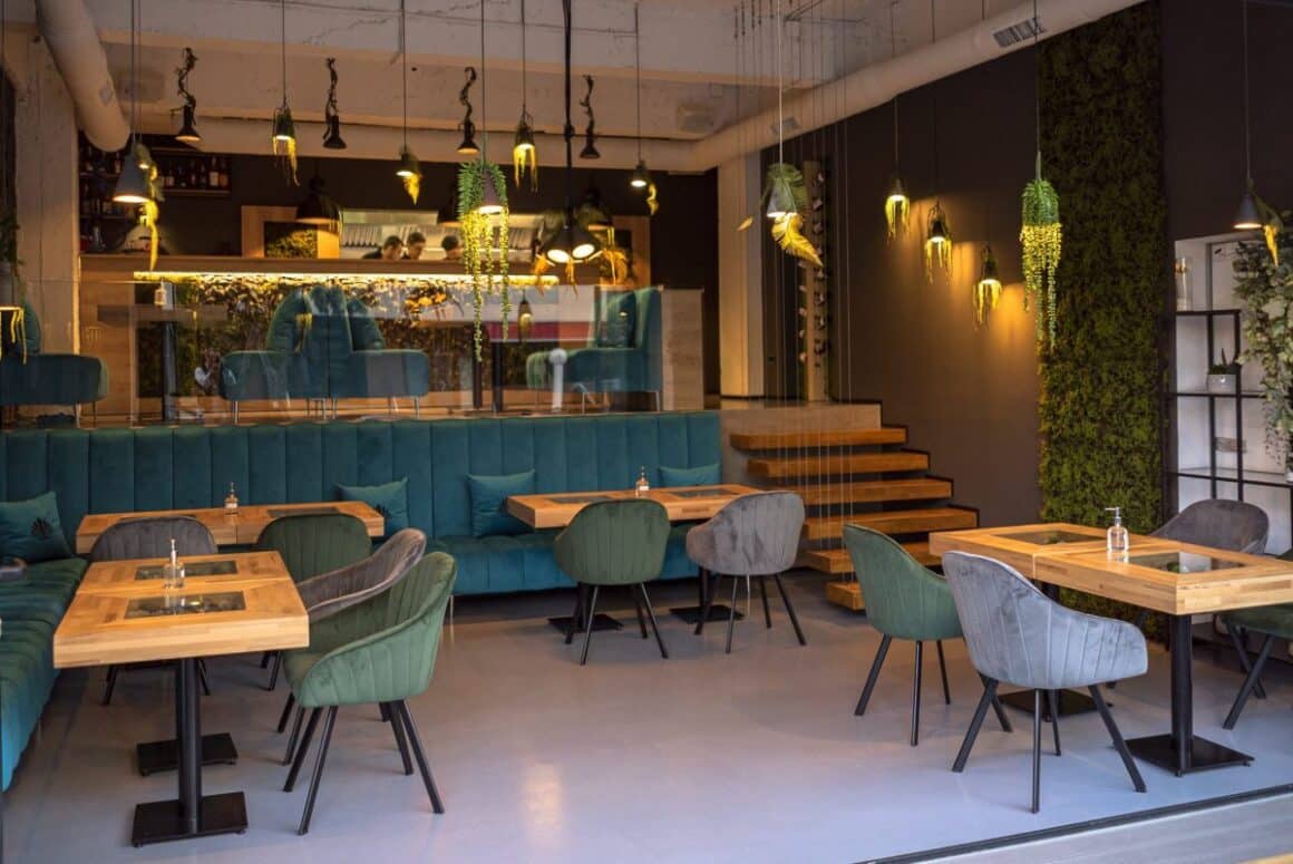 Interiorul restaurantului More Sushi, amenajat modern, cu mese de lemn si scaune si canapele din catifea albastra - restaurante japoneze București