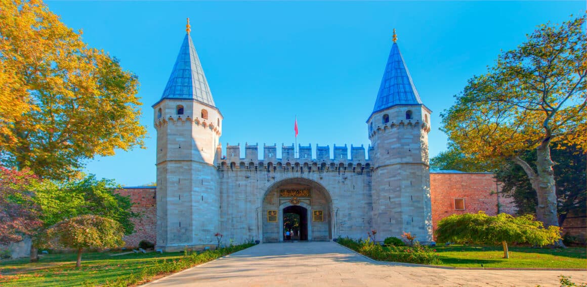 Intrarea in Palatul Topkapi din Istanbul, fotografiat din exterior, cu poarta de intrare strajuita de 2 turnuri inalte