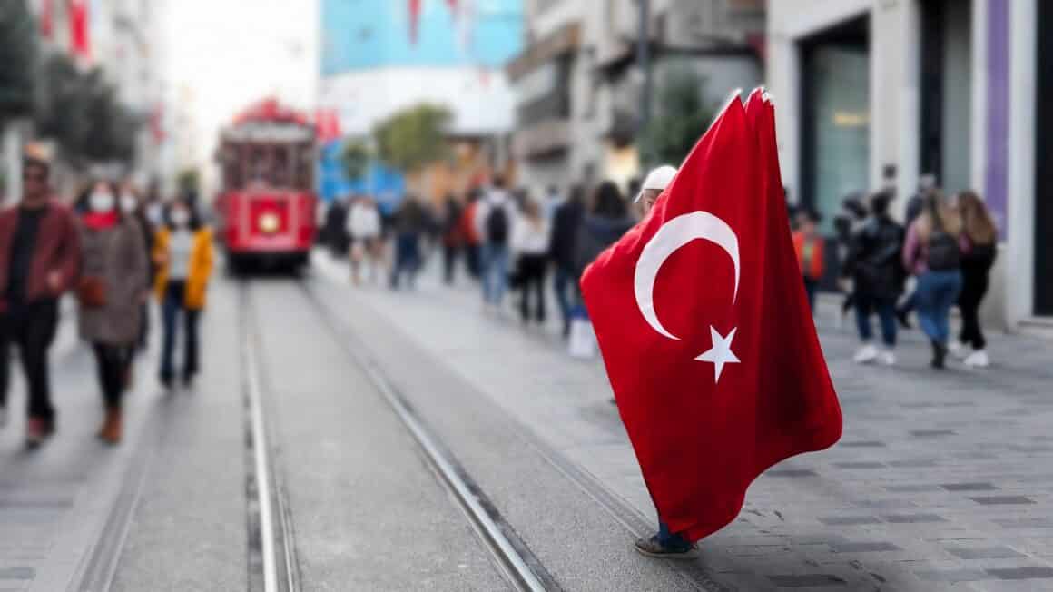 barbat infasurat in steagul Turciei, in Piata Taksim, de vizitat in Istanbul