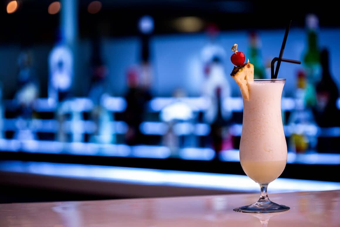 pahar de Pina Colada asezat pe bar, unul din cocktailuri pentru fete