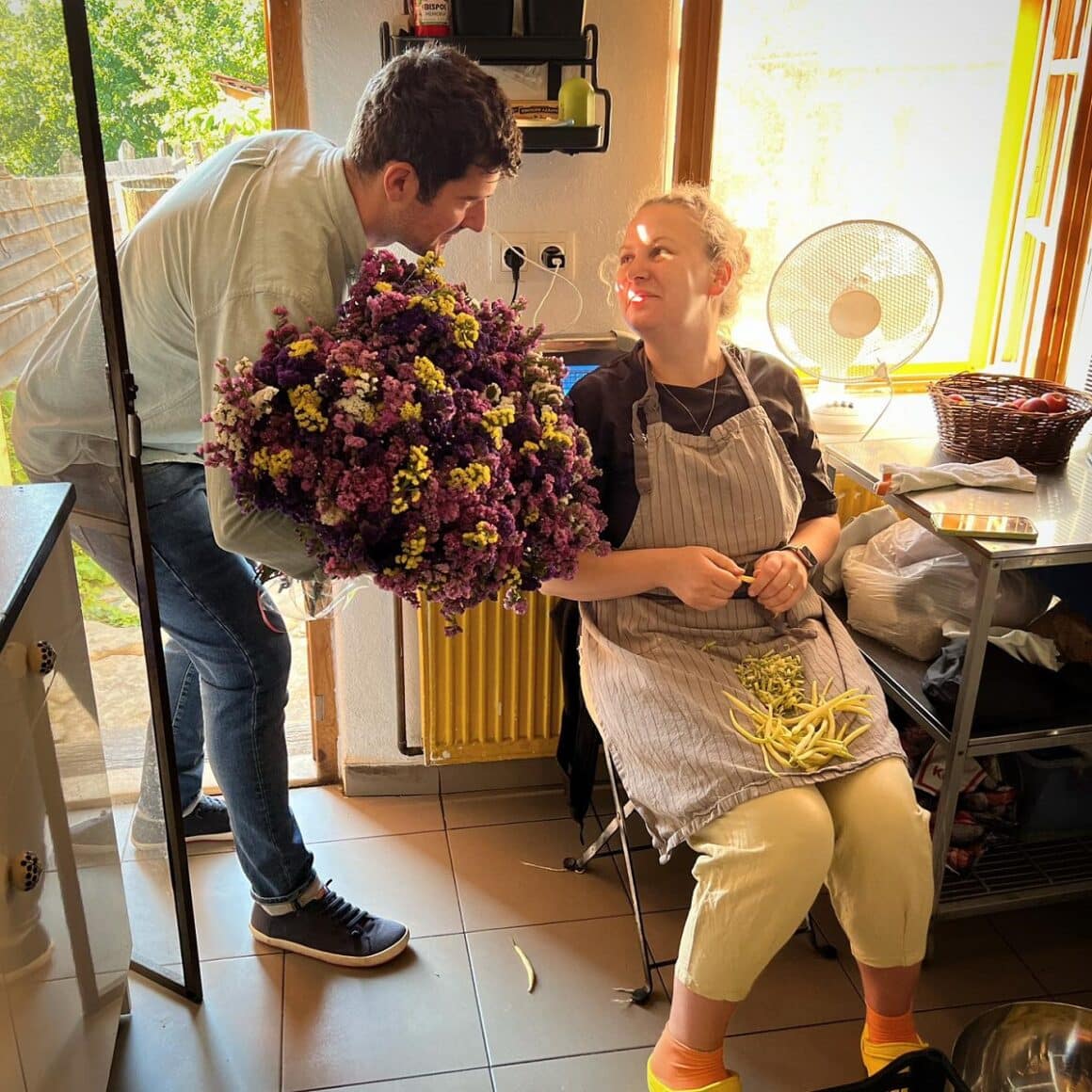 Mara Elena Oană in sort de bucatarie, curata fasole verde si primeste flori de la un barbat