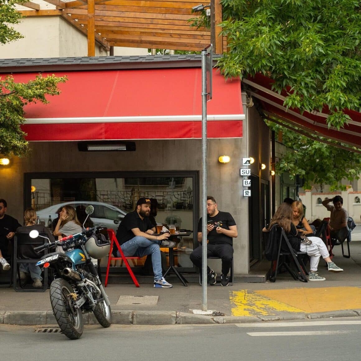 clienti asezati la2 mese pe trotuar in fata la Ai Sushi - restaurante japoneze București