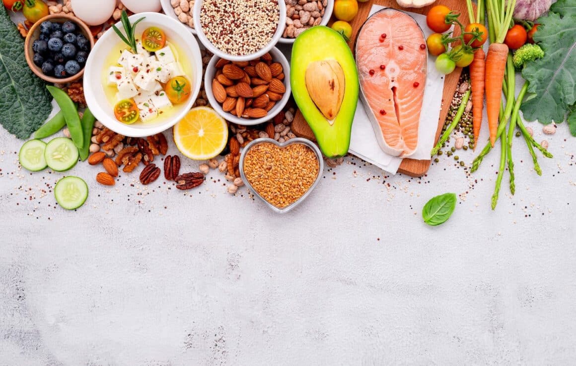 Imagine concept pentru dieta nordică, cu diverse alimente fotografiate pe fundal gri - peste crud, avocado, seminte, nuci, fructe, legume