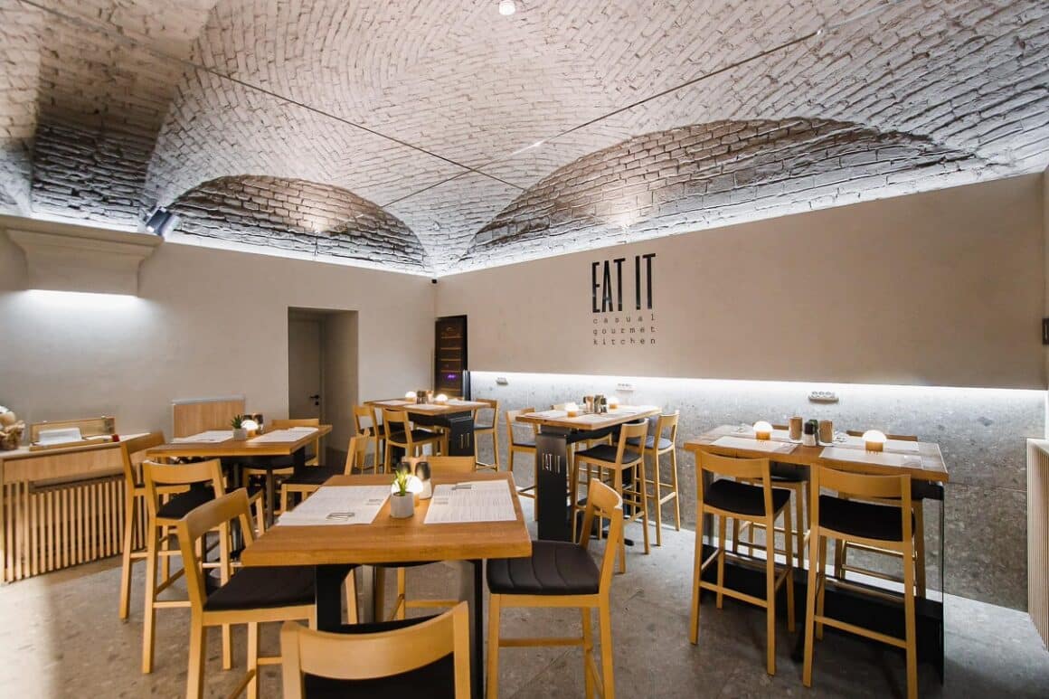 imagine de ansamblu din restaurant Eat IT din Oradea, cu mese de lemn de 4 persoane, pereti si tavan alb din caramida aparenta