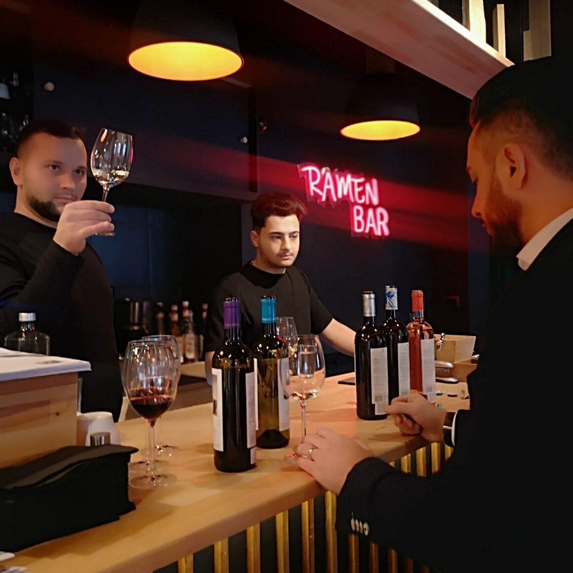 doi barmani servesc un client la Kanpai Bistro