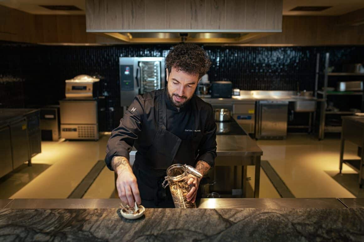 Chef Alexandru Dumitru aranjeaza platingul la un preparat de la restaurant La Hambar, unul din restaurante destinație din țară