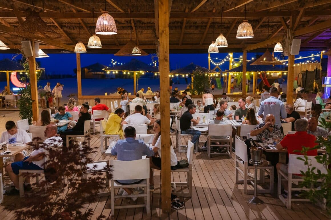 oameni care iau masa seara la terasa IpaNera din Constanta, de 1 Mai la mare