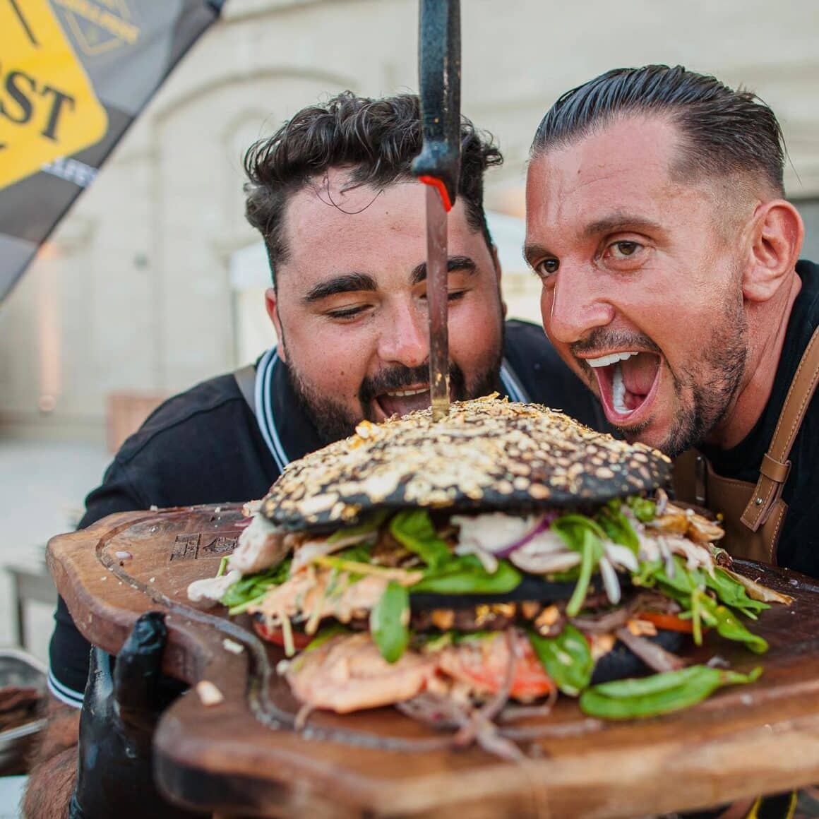 2 chefi care mimeaza ca musca dintrpun burger la Grill fest 2023
