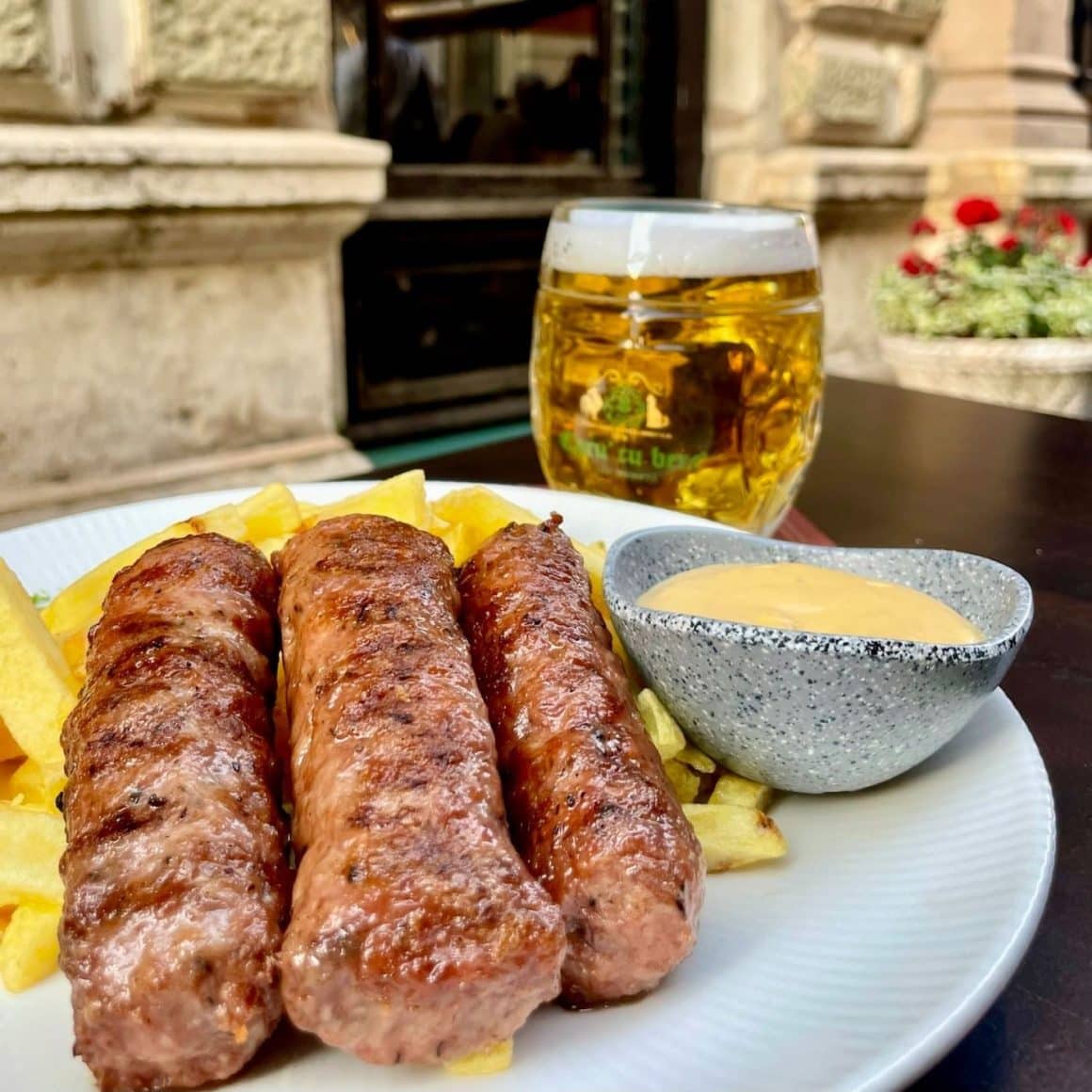 close up cu o farfurie de mici, mustar si o halba de bere. Unde iesim de 1 Mai. Caru cu bere
