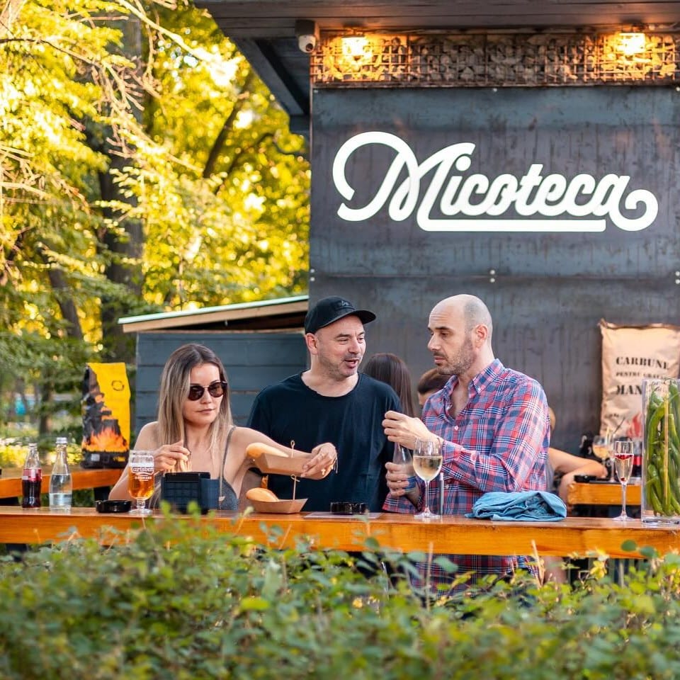 grup de tineri mananca mici pe terasa la Micoteca Herăstrău. Unde ieșim de 1 mai