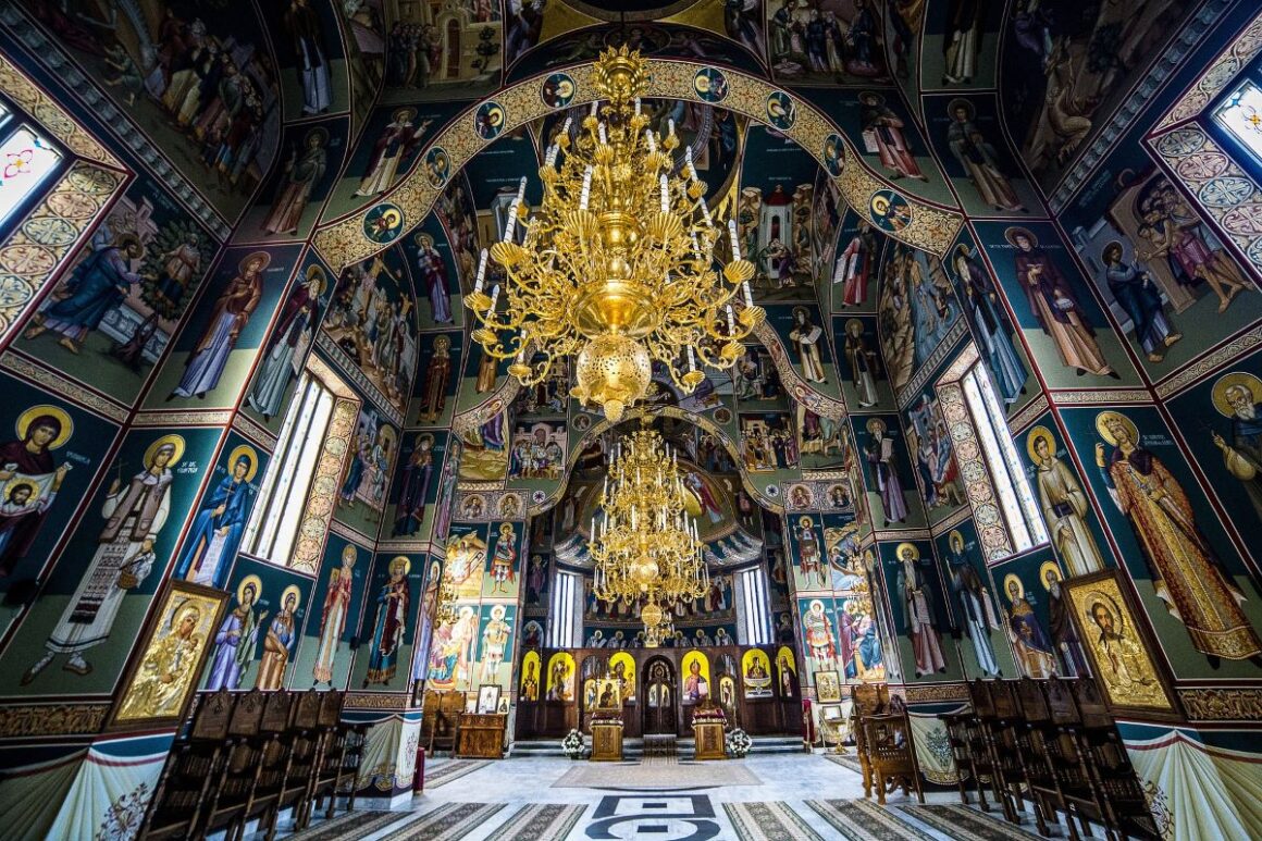 Paștele în Bucovina: interiorul mănăstirii Putna cu un candelabru in prim plan