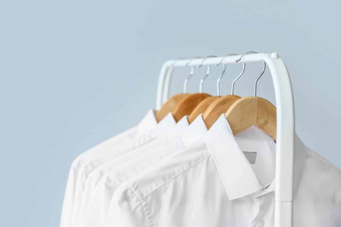 Suport de haine pe care sunt atarnate umerase cu camasi albe - solutie pentru indepartarea petelor rezistente