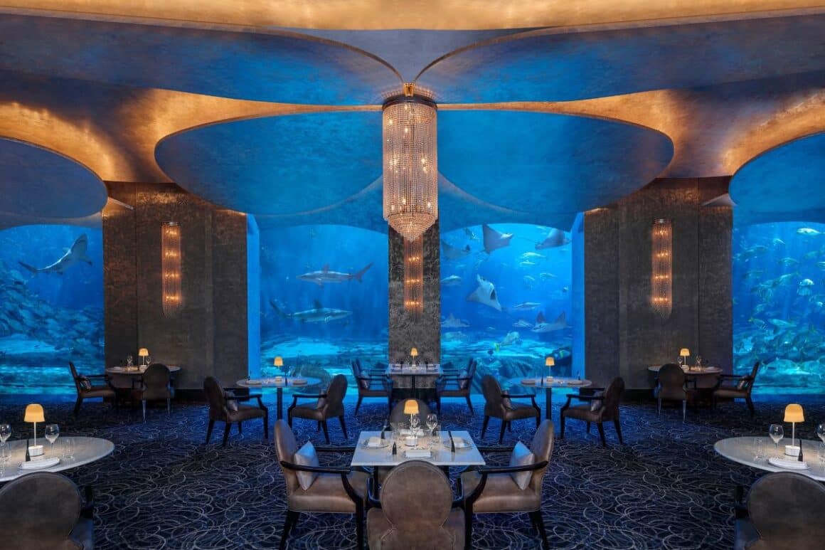interiorul foarte impunător al resaurantului ossiano din dubai, cu mese asezate in fata unui acvariu imens, cat tot restaurantul. top restaurante Dubai