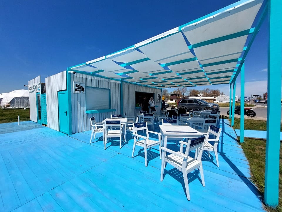 terasa cu podea albastra si mobilier alb la Glamping by the Sea Mamaia Nord
