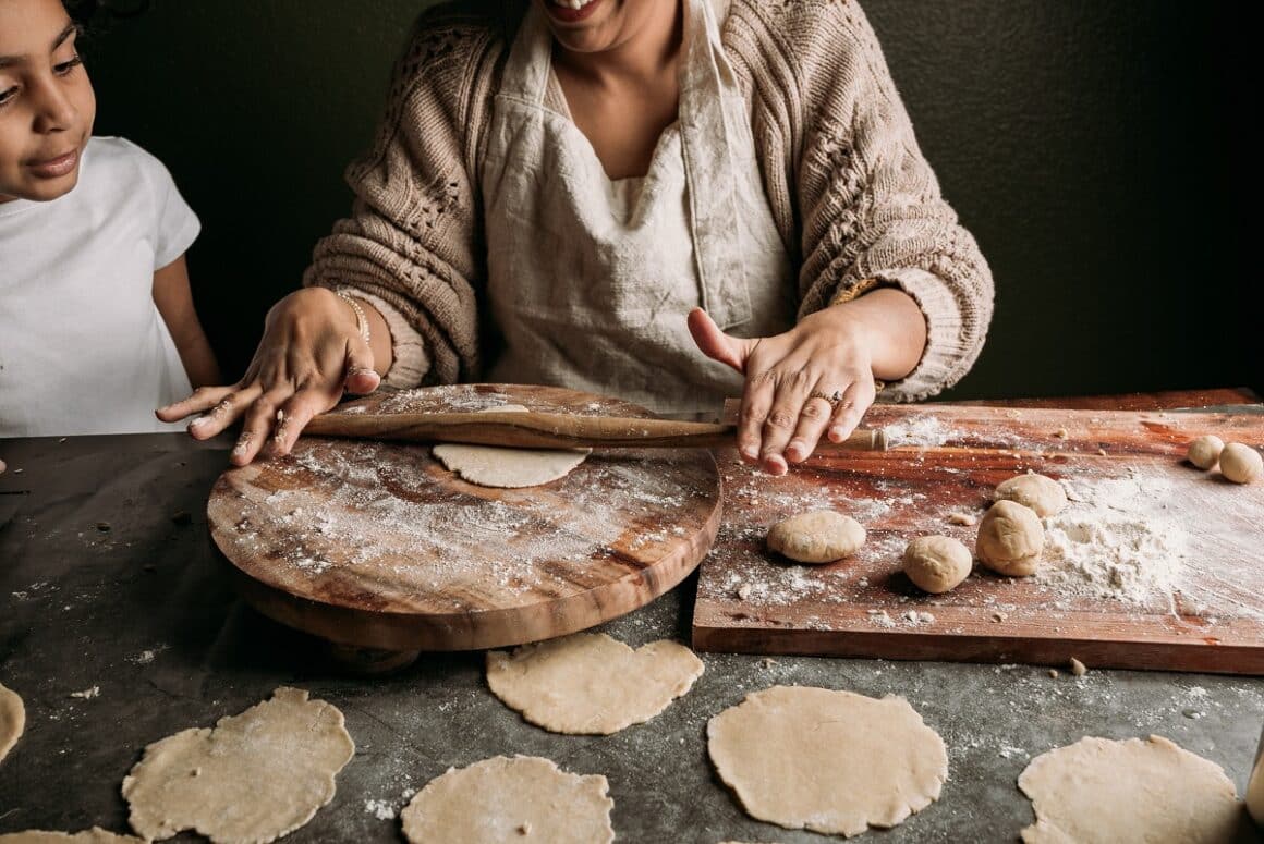 Mama si fiica din India prepara painici naan cu sucitor belan si tocator chackla