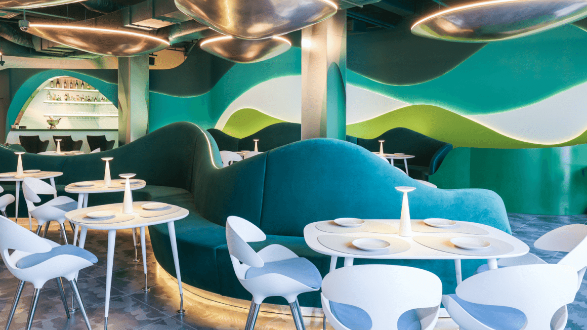 interiorul restaurantului Raionul de Pește floreasca, deocrat în nuanțe marine, cu mese si scaune albe, canapea albastra din catifea si pereti pictati in nuante de albastru si verde, in model valurit. Design semnat de Karim Rashid. Locuri noi în București