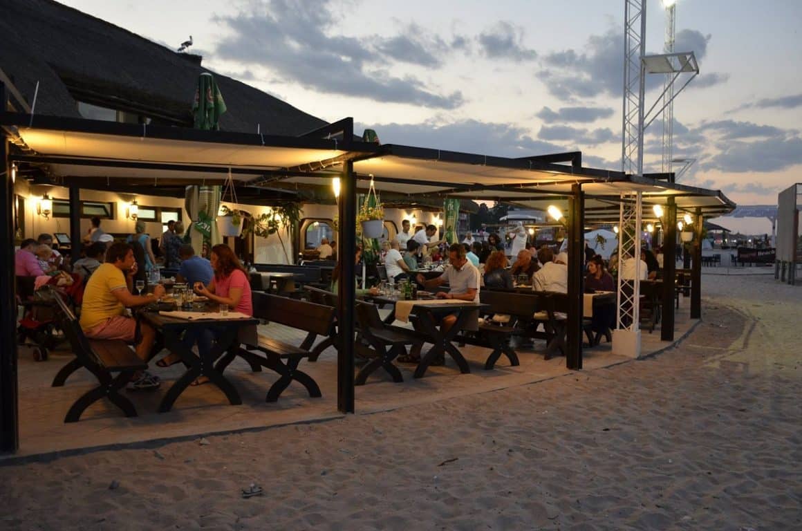 Oameni care iau masa seara pe terasa la La Stuf, cherhanale de pe litoralul românesc