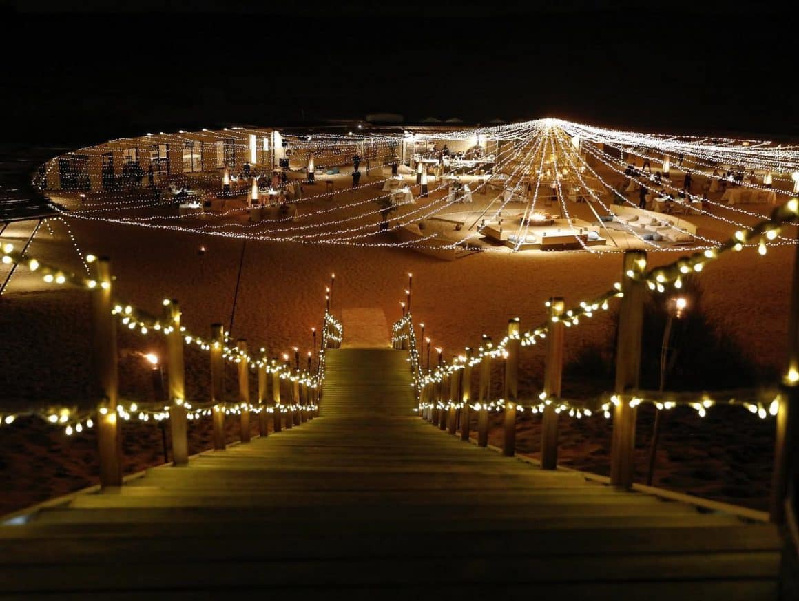 Sonara Camp fotografiata noaptea, cu mese dispuse in cerc sub o cupola de luminite. Cină extravagantă în Dubai
