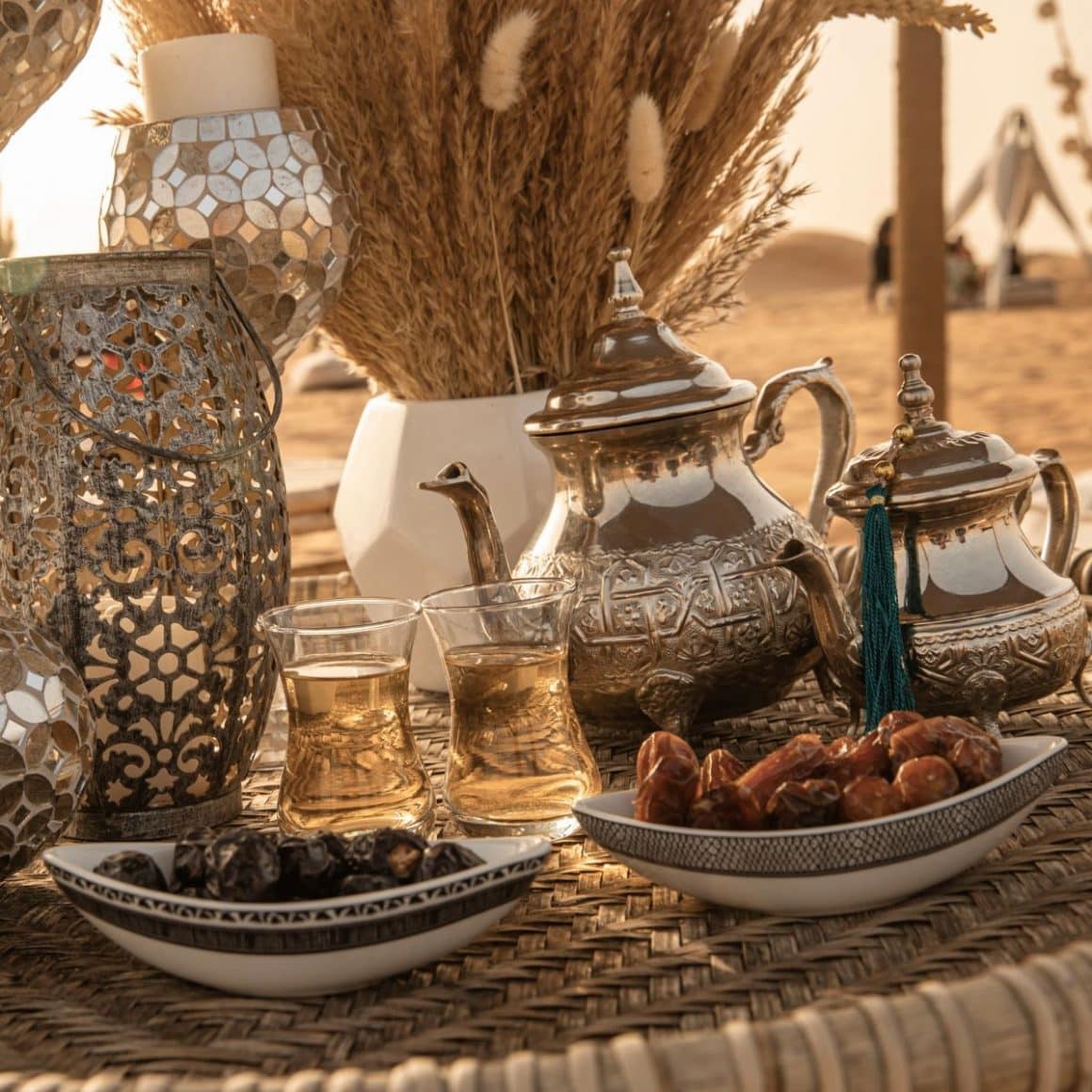 mai multe vase traditionale sunt asezate pe o masă de răchită în restaurantul din desertul dubaiului