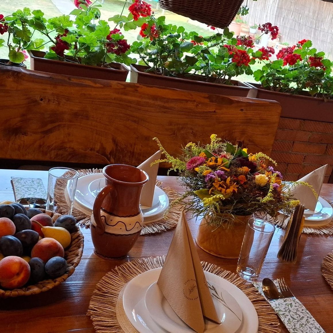 Masă aranjată cu ulcior de lut și fructe de sezon, la Acasă la Maya, Rudăria, Valea Almăjului