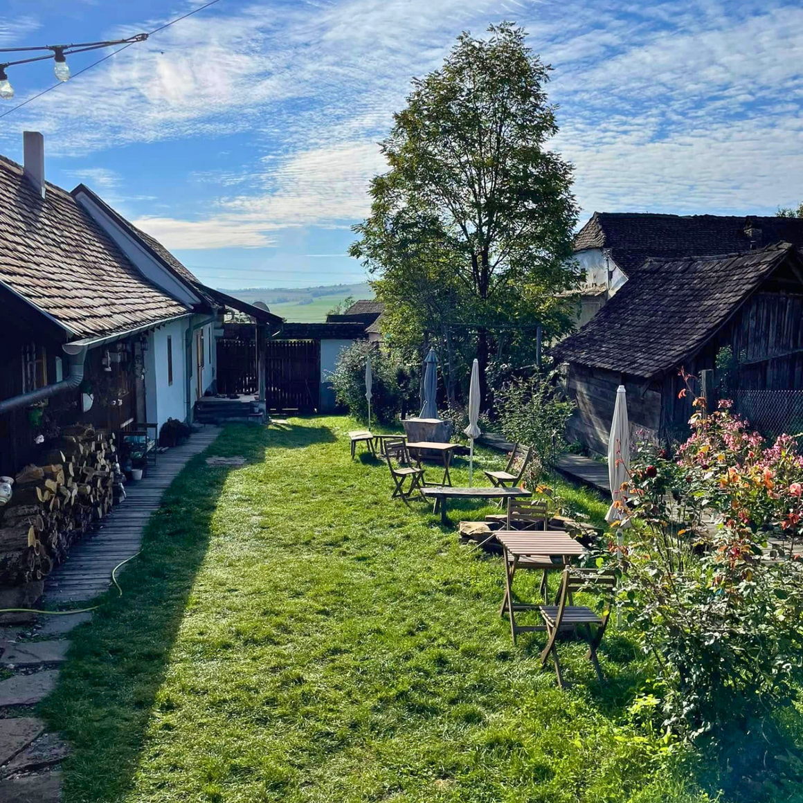 Curtea gospodăriei săsești Meșendorf 65 din Brașov, cu mese pentru degustări în aer liber. Puncte gastronomice locale