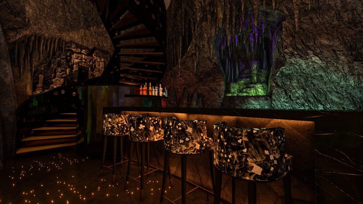 Bar cu mese inalte amenajat intr-o pestra, cu lumina difuza, la The Cave, Bali. Cină extravagantă