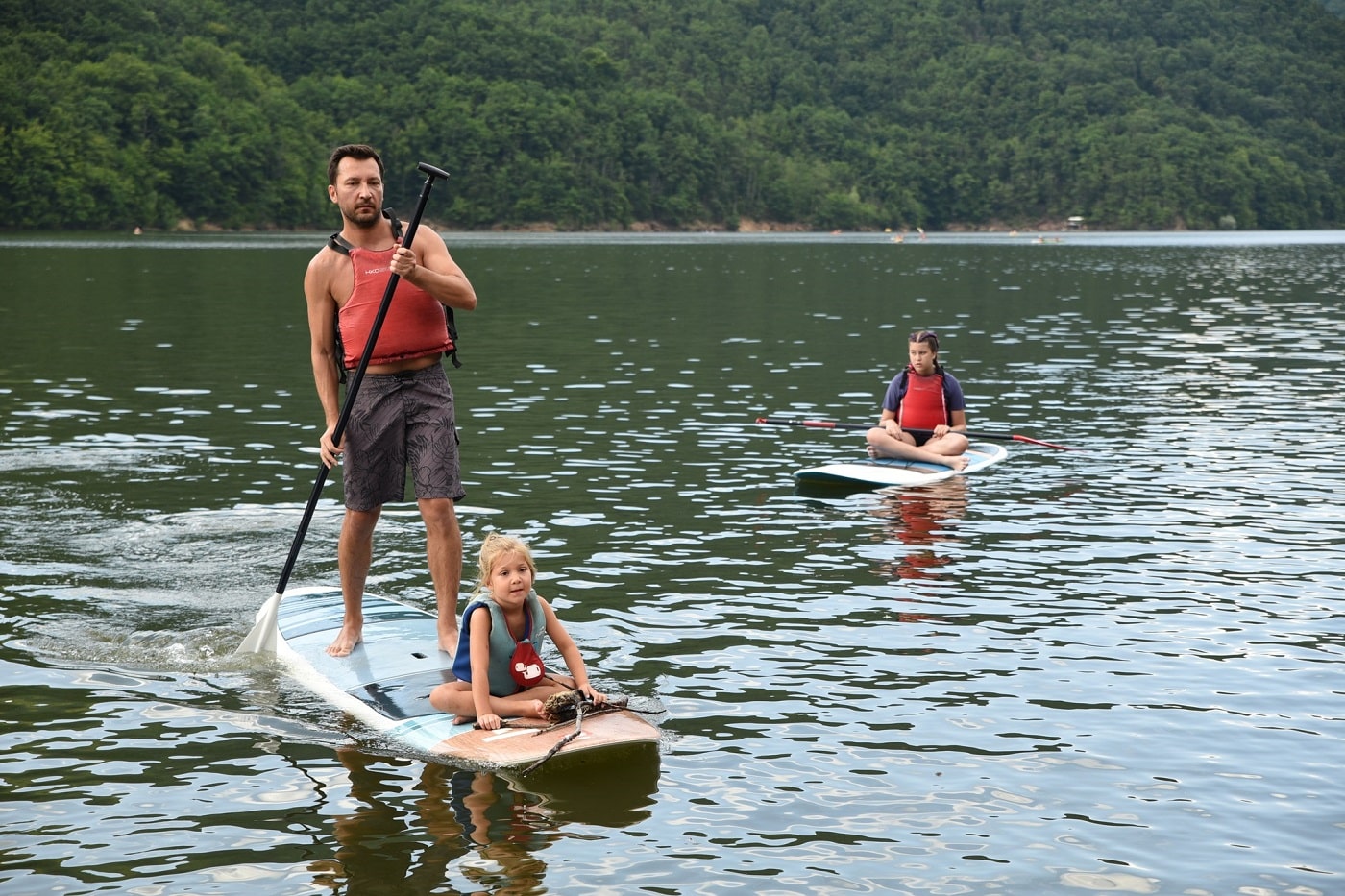 un tata si fetita lui pe un paddle, pe lacul Tarnița din CLuj. Destinații de vară pentru familiile cu copii