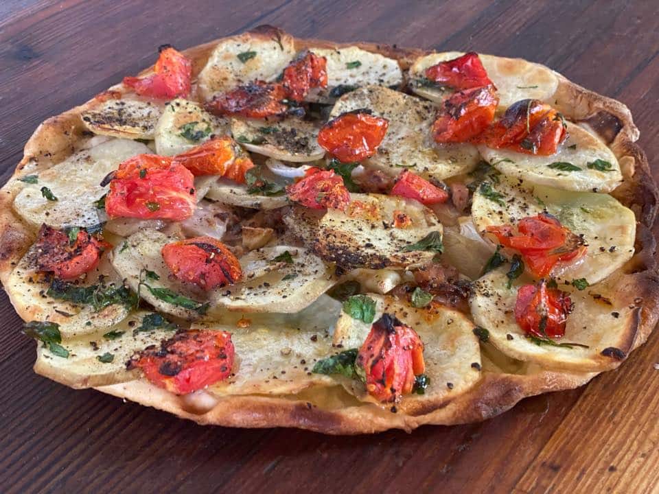ftira tradițională malteză, un fel de pizza  cu brânză malteză (gbejna), măsline, roșii, ceapă și alte legume.