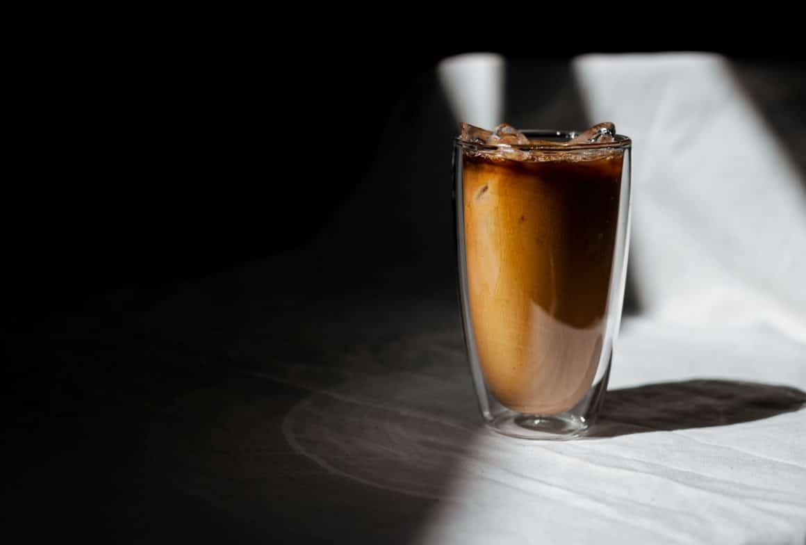 un pahar de frappe grecesc fotografiat in semiintuneric băuturi reci din cafea