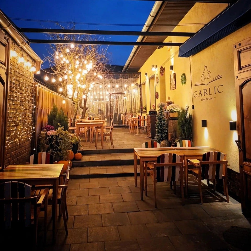 terasa de la restaurant Garlic Cluj, fotografiata seara, cu beculete decorative