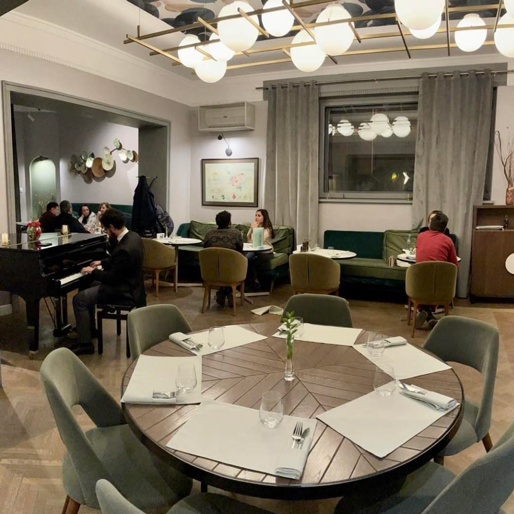 Interiorul Restaurantului Savart, elegant, cu omeni care iau masa. Restaurante franțuzești București