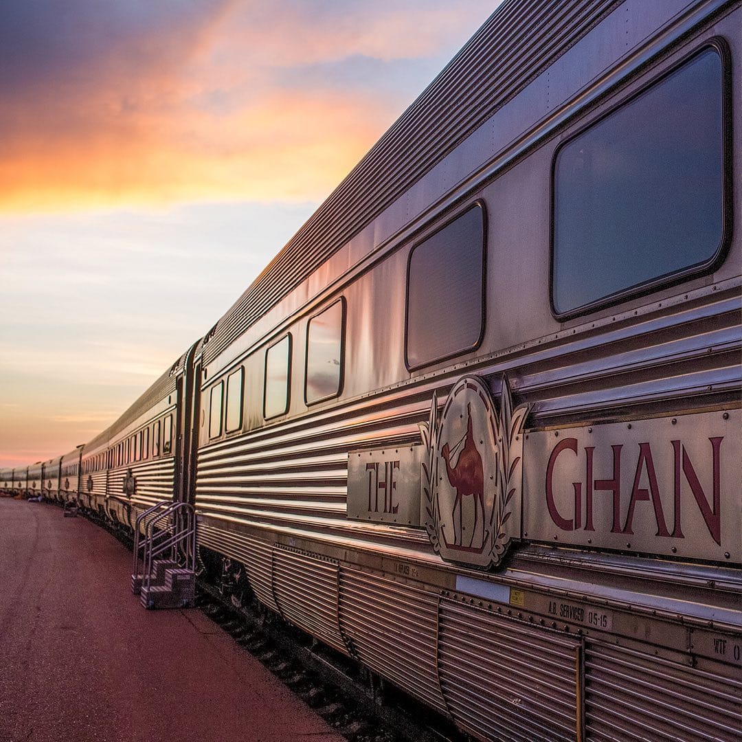 vagoanele unui tren sunt fotografiate intr-o gară, la apus. trenuri internaționale de lux