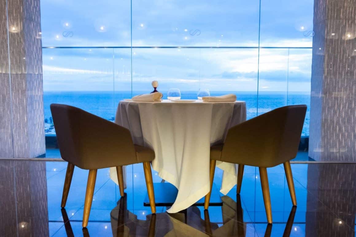 doua scaune si o masa sunt fotografiate in fata unui perete de sticla la El Rincon de Juan Carlos. restaurante din Tenerife
