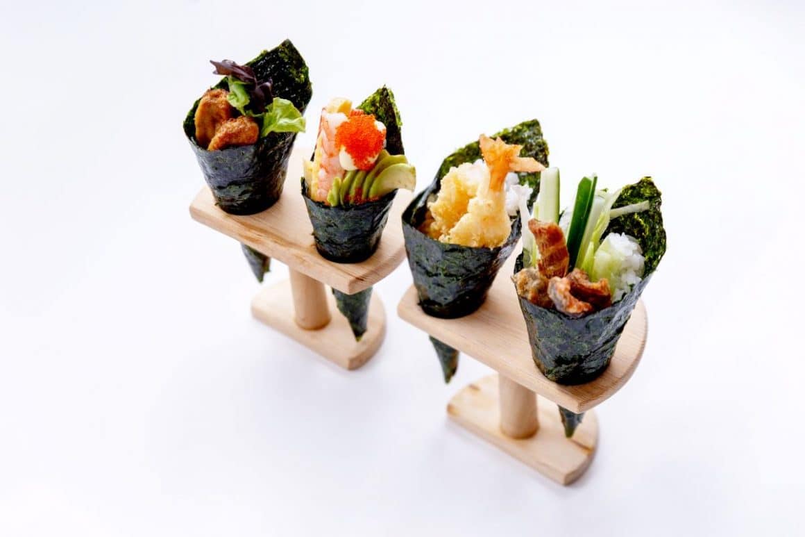 patru conuri de temaki sushi puse in doua suporturi de lemn. Cum se mănâncă sushi