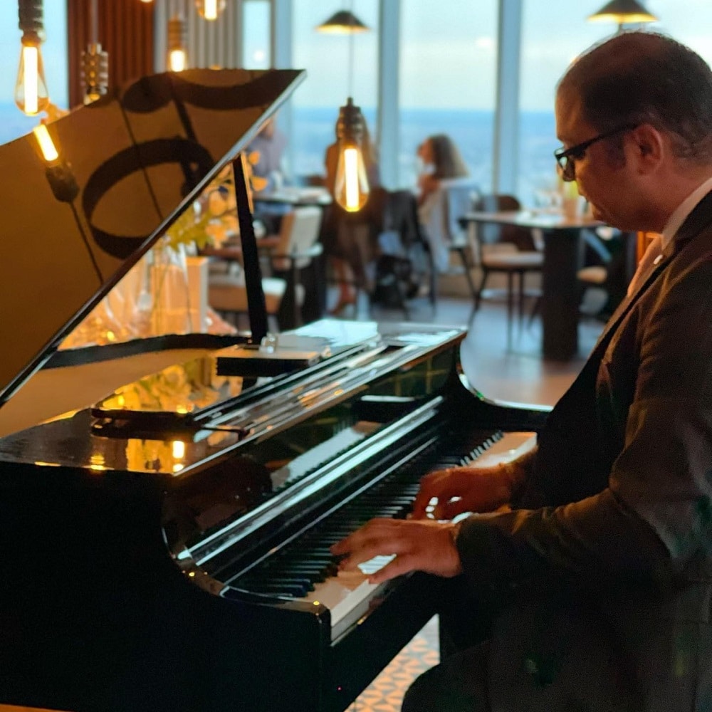 un pianist in prim plan, canta la clape, la NOR București. Restaurante cu muzică live