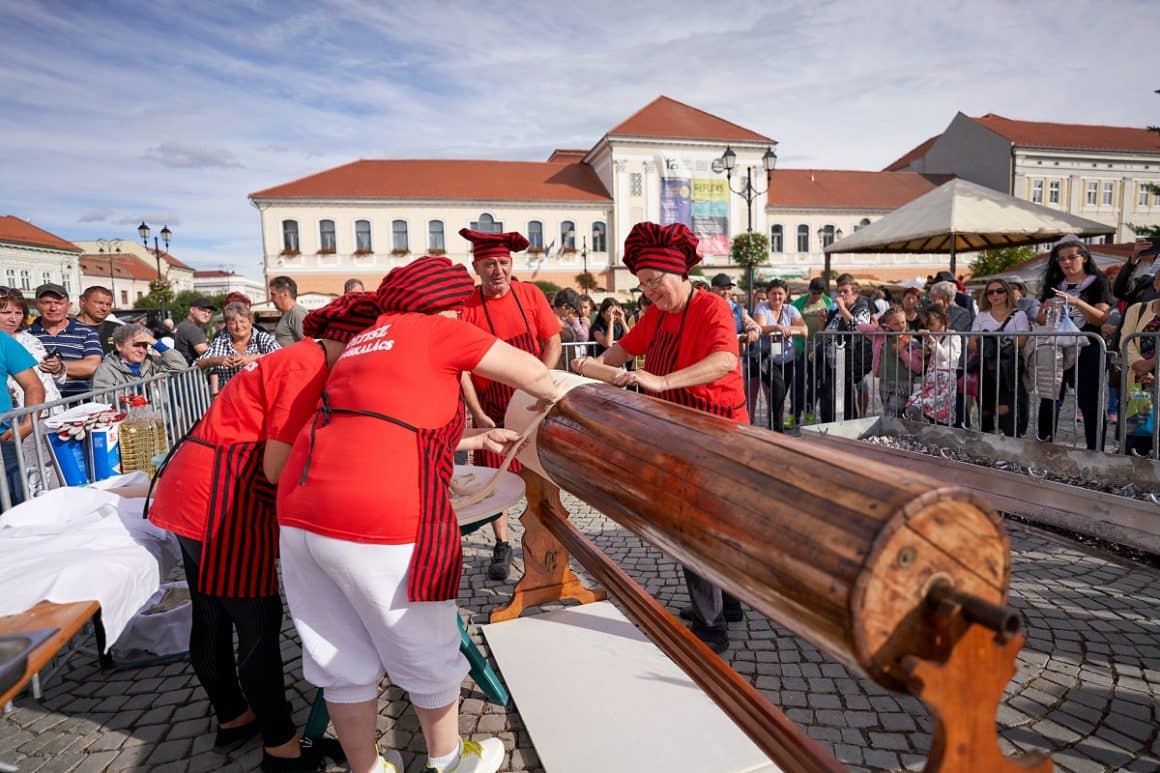bucatarese prepara un kurtosfolak gigantic, la festivalul deliciilor dulci din Sfântu Gheorghe, unul din locul unde se organizează târguri gastronomice de toamnă